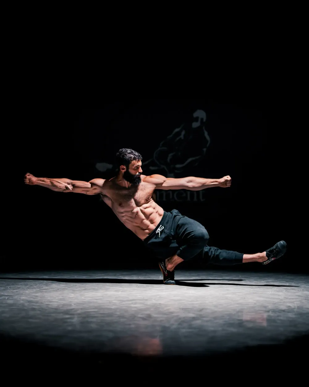 Roye Gold mid-movement on a dark stage